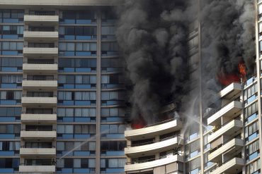 Firefighters on several balconies spray water upwards while trying to contain a fire at the Marco Polo apartment complex, Friday, July 14, 2017, in Honolulu. (AP Photo/Marco Garcia)